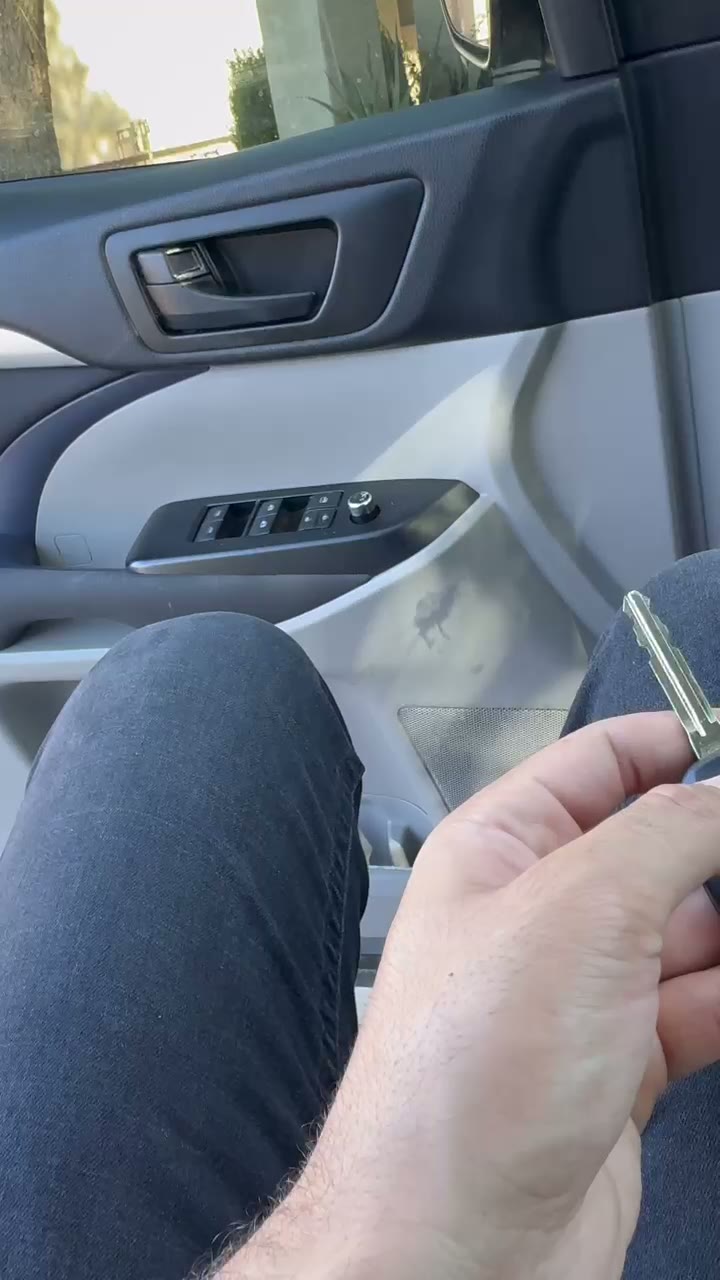 Liza Locksmith technician holding two freshly cut Toyota keys inside the vehicle after on-site programming