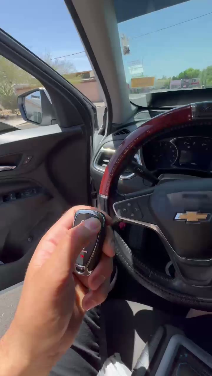 Liza Locksmith technician testing a newly programmed remote key fob inside a GM vehicle
