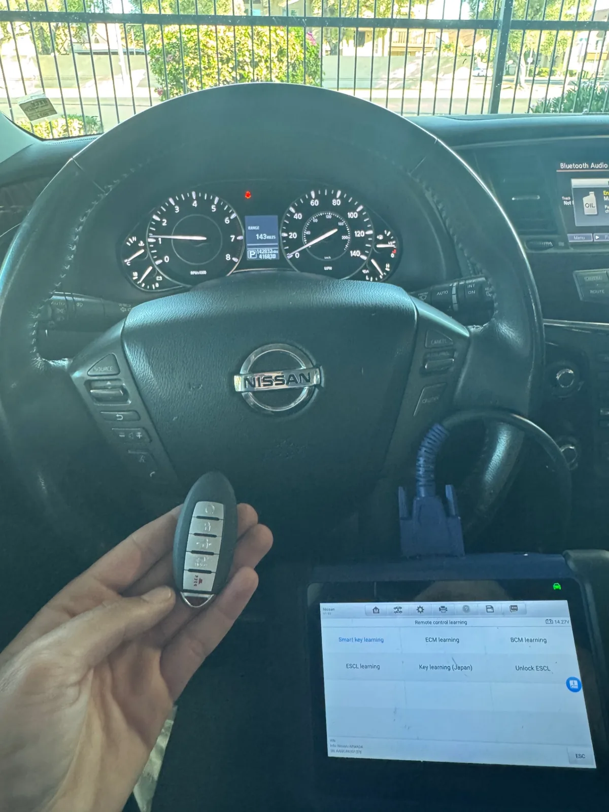 Automotive diagnostic tablet connected during a real key programming job inside a Nissan